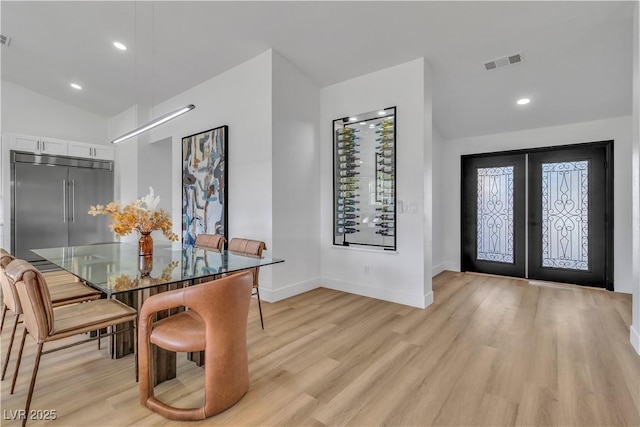 dining space with french doors, visible vents, light wood finished floors, and baseboards