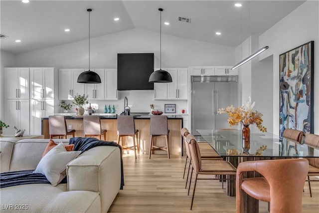 interior space with recessed lighting, visible vents, light wood-type flooring, and high vaulted ceiling