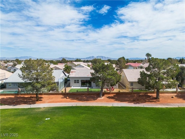 view of community featuring a mountain view, a yard, and a residential view