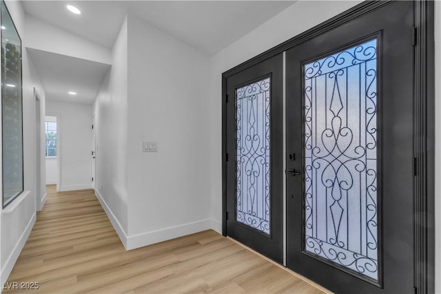 entryway with light wood-style flooring, recessed lighting, and baseboards