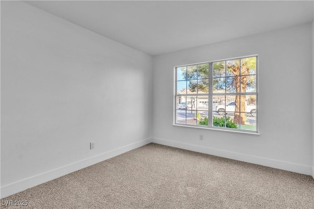 carpeted empty room featuring baseboards