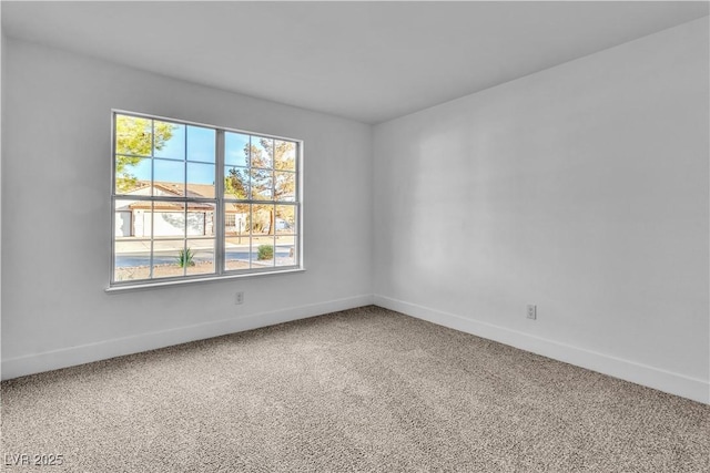 carpeted spare room featuring baseboards