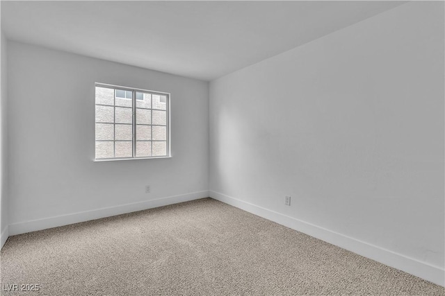 unfurnished room with carpet flooring and baseboards