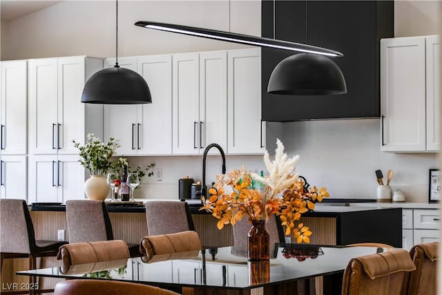 kitchen with decorative light fixtures, white cabinets, and light countertops