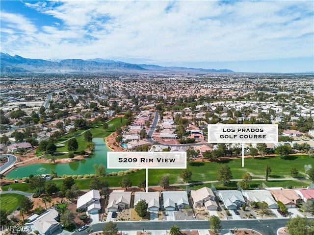 drone / aerial view featuring golf course view, a residential view, and a water and mountain view