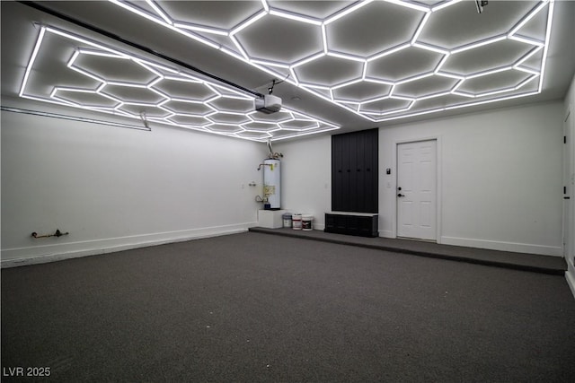 interior space with a garage, gas water heater, speckled floor, and baseboards