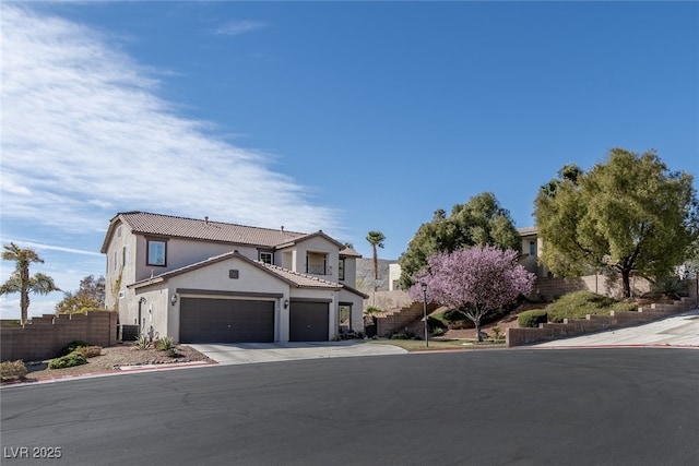 view of front of home featuring a garage, fence, driveway, and stucco siding