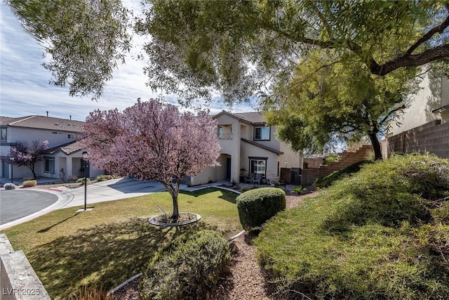 view of front of house featuring a front yard, fence, and stucco siding