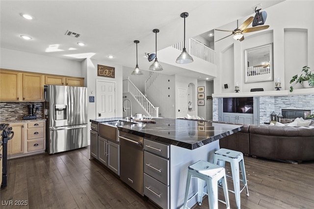 kitchen with visible vents, dark wood finished floors, appliances with stainless steel finishes, open floor plan, and a sink