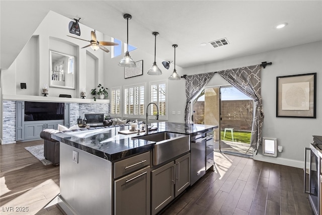 kitchen with a fireplace, visible vents, dark wood finished floors, and a sink