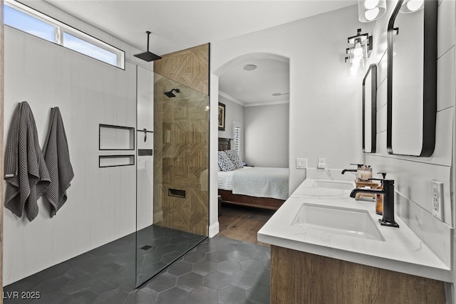 ensuite bathroom with connected bathroom, tile patterned floors, a sink, and walk in shower