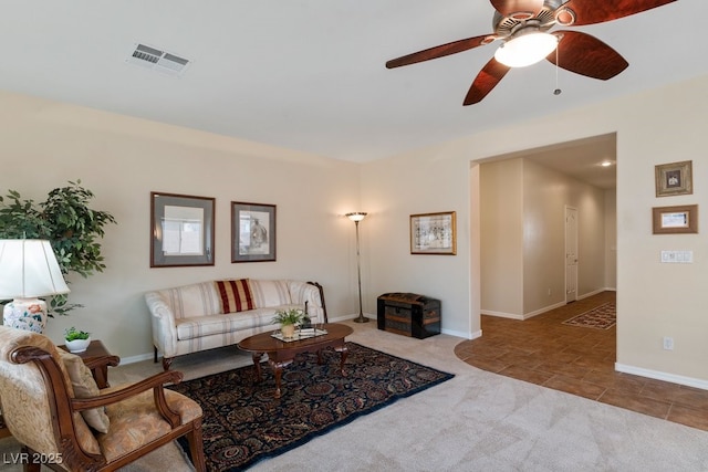 carpeted living area featuring visible vents, a ceiling fan, and baseboards