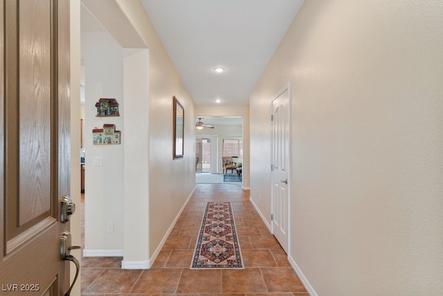 hallway with recessed lighting and baseboards