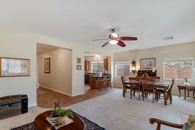 dining area with light carpet, visible vents, ceiling fan, and baseboards