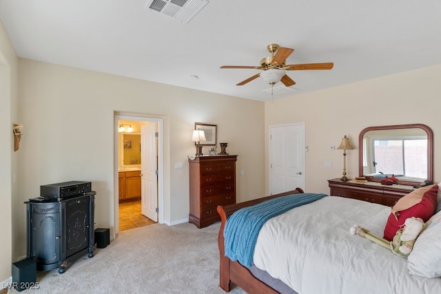 bedroom with a ceiling fan, baseboards, visible vents, light colored carpet, and connected bathroom