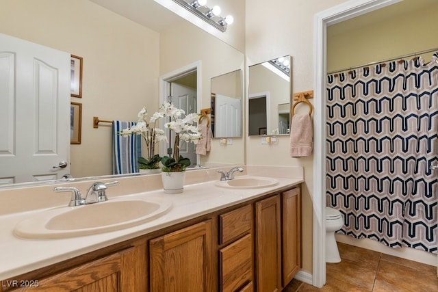 full bath with tile patterned floors, toilet, double vanity, and a sink