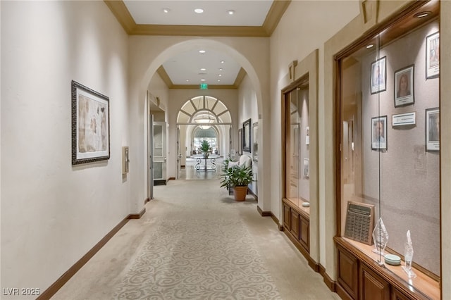 corridor with recessed lighting, baseboards, arched walkways, and ornamental molding