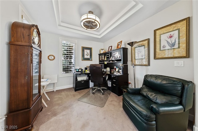 carpeted office with baseboards and a tray ceiling