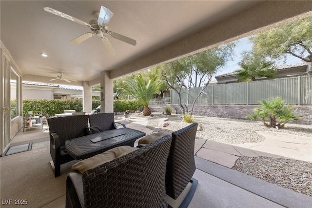 view of patio with outdoor lounge area, fence, and ceiling fan