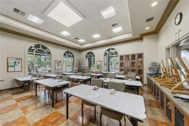 dining room featuring a tray ceiling, visible vents, and a high ceiling