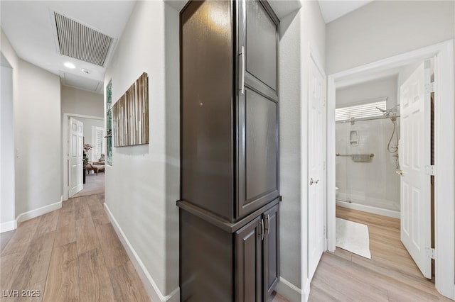 corridor with visible vents, light wood-style flooring, and baseboards