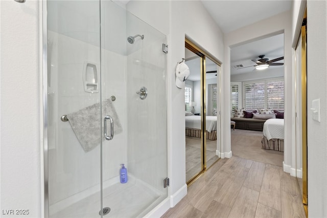 ensuite bathroom with a stall shower, visible vents, wood finished floors, and ensuite bathroom