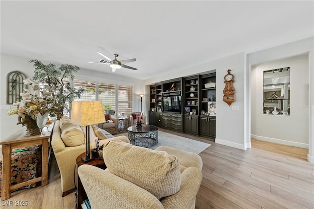 living room featuring light wood-style floors, baseboards, and a ceiling fan