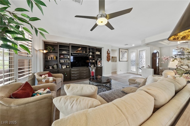 living area with light wood-type flooring, french doors, ceiling fan, and baseboards