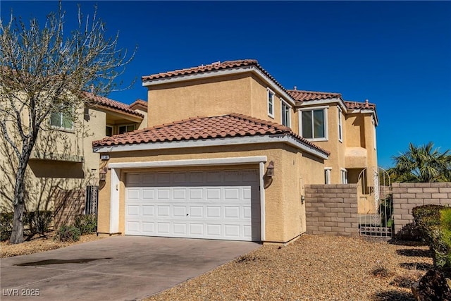 mediterranean / spanish-style house featuring driveway, an attached garage, a tiled roof, and stucco siding