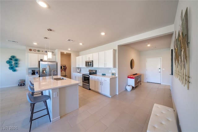 4400 E Cactus Canyon Dr, Pahrump, NV 89061 - kitchen with visible vents, appliances with stainless steel finishes, a breakfast bar, and a sink