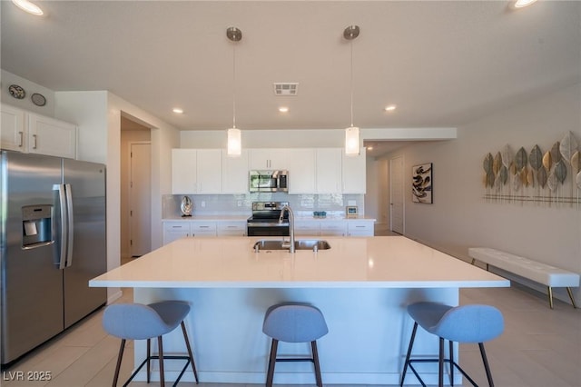 4400 E Cactus Canyon Dr, Pahrump, NV 89061 - kitchen featuring visible vents, appliances with stainless steel finishes, a kitchen breakfast bar, a sink, and backsplash