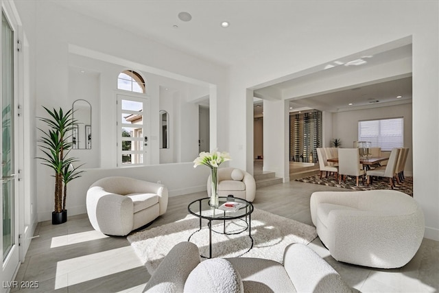 living area featuring baseboards, light wood finished floors, and recessed lighting