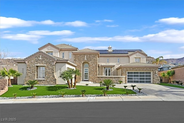 view of front of property featuring a garage, concrete driveway, roof mounted solar panels, a front lawn, and stucco siding