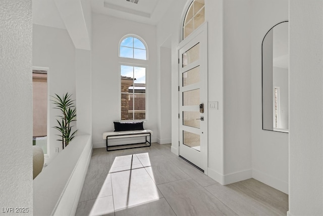 entryway with a high ceiling, visible vents, and baseboards