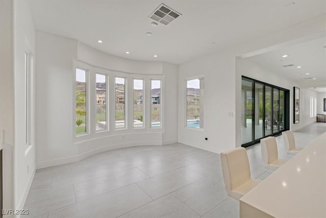 spare room featuring a healthy amount of sunlight, visible vents, and recessed lighting