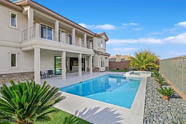 view of swimming pool featuring a patio area, a fenced backyard, and a pool with connected hot tub