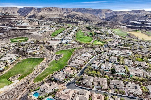 drone / aerial view with a residential view, a mountain view, and golf course view