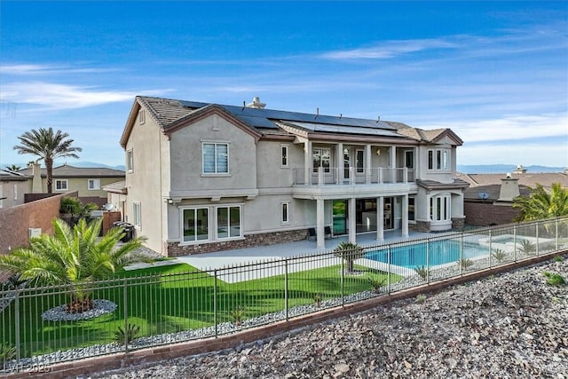 back of house with a patio, a fenced backyard, a balcony, and stucco siding