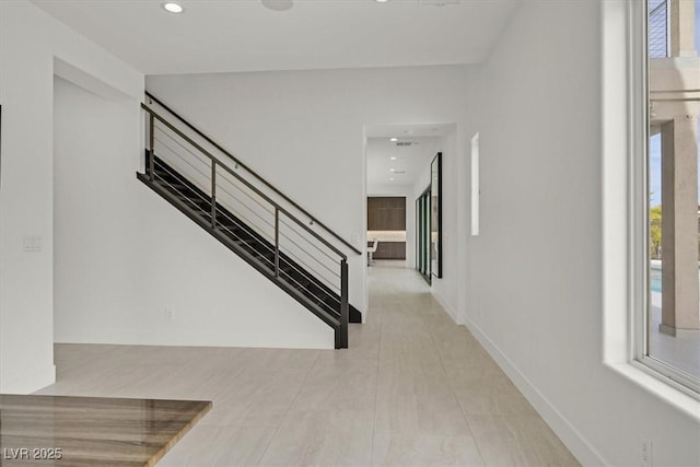 entryway featuring baseboards, stairway, and recessed lighting