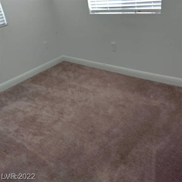 carpeted spare room with baseboards