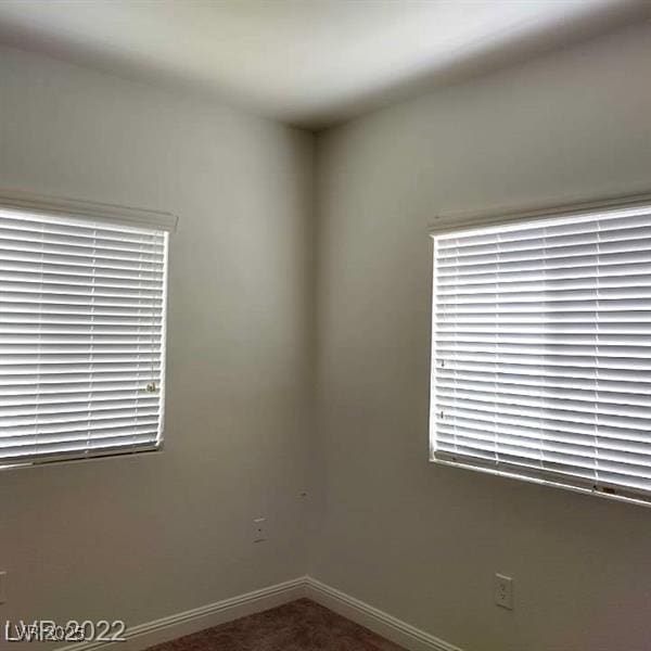 unfurnished room featuring carpet and baseboards