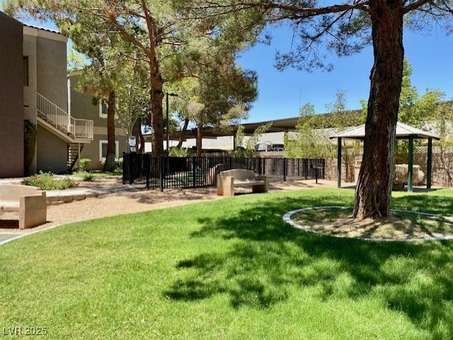 view of community with a lawn, stairway, and fence