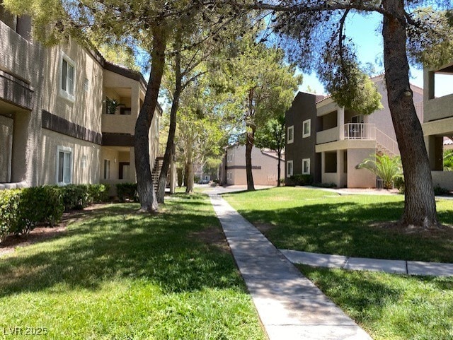 view of community with stairway and a lawn