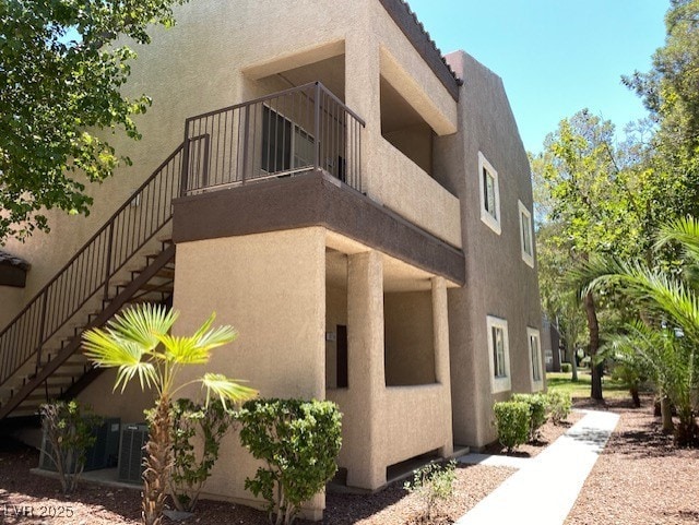 view of property exterior with stairway and stucco siding