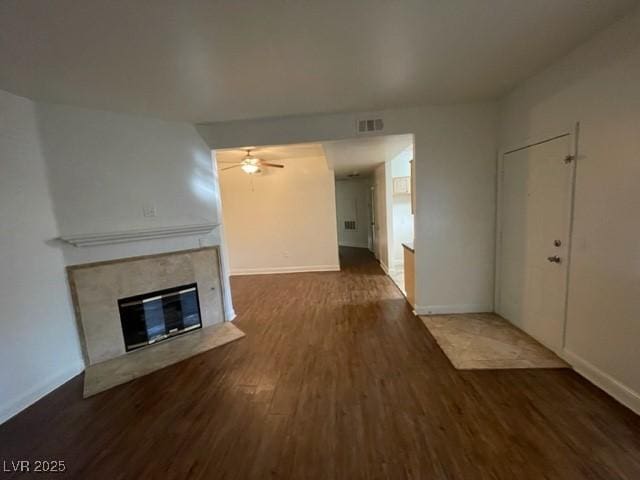 unfurnished living room with a fireplace, wood finished floors, and baseboards