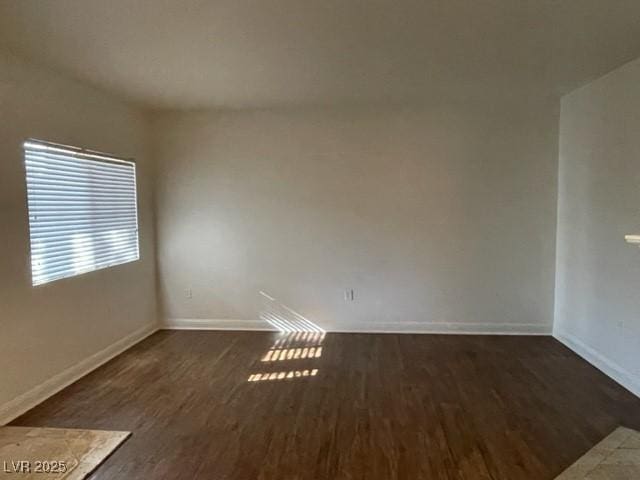 spare room featuring wood finished floors and baseboards