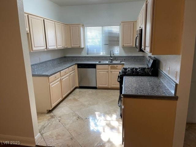 kitchen with dark countertops, appliances with stainless steel finishes, and a sink