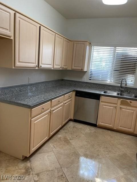 kitchen featuring dark countertops, light brown cabinets, a sink, and dishwasher