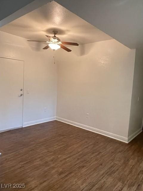 unfurnished room with ceiling fan, baseboards, and dark wood-type flooring