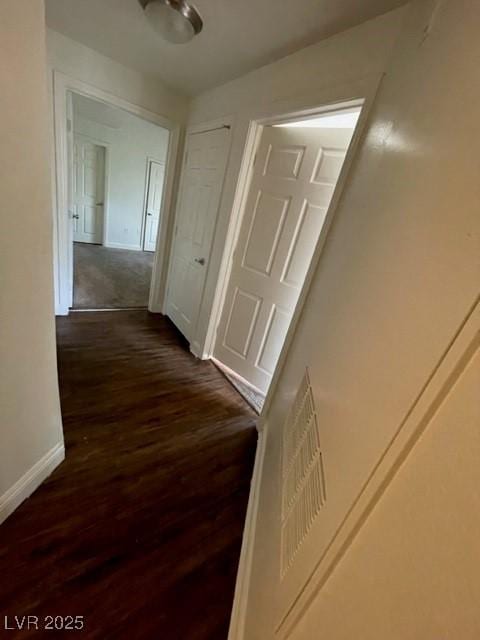 hallway with dark wood-style flooring and baseboards